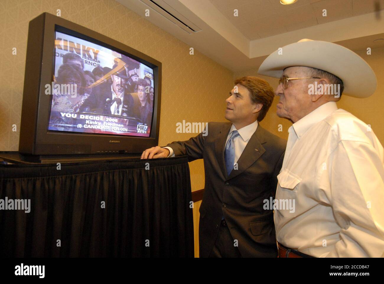 Austin, Texas 7 novembre 2006: Le gouverneur du Texas Rick Perry (l) et son père Ray (r) regardent le challenger Kinky Friedman concéder la course du gouverneur à Perry à la télévision. ©Bob Daemmrich Banque D'Images
