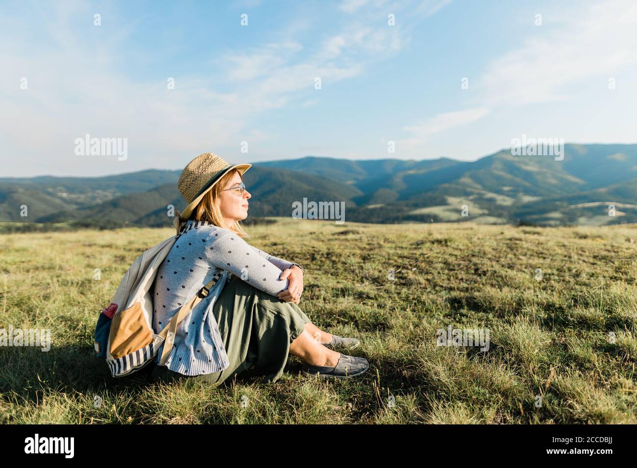 Jeune femme amoureux de la nature appréciant le coucher de soleil dans les montagnes Banque D'Images