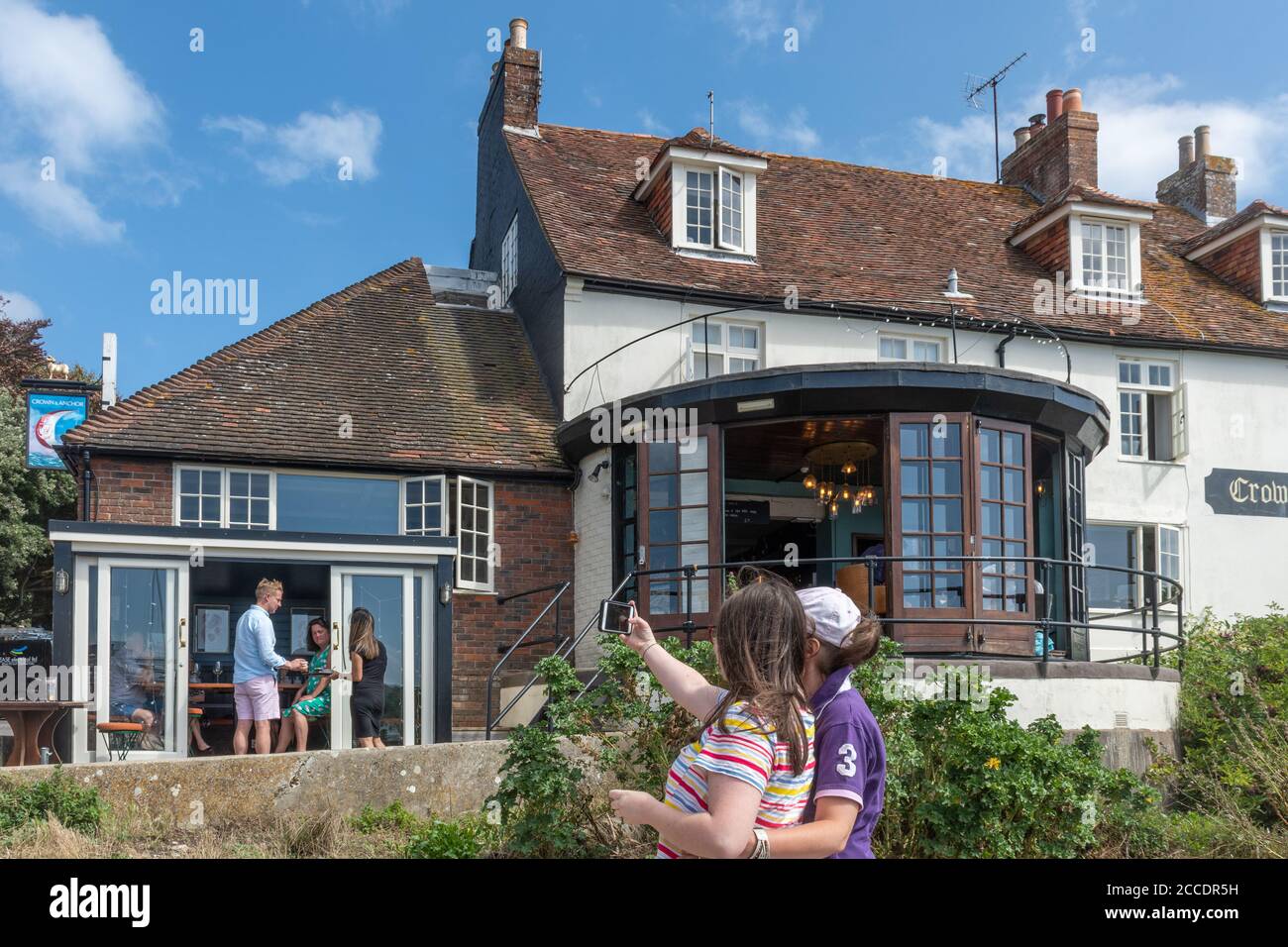 Visiteurs prenant des selfies au pub Crown and Anchor de Dell Quay, Chichester Harbour, West Sussex, Royaume-Uni Banque D'Images