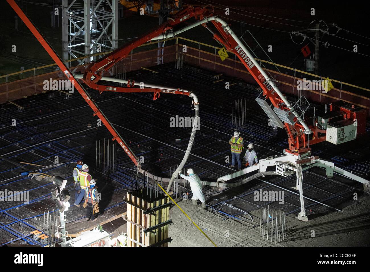 Austin, TX USA 25 juillet 2020: Le béton pompé coule à travers un tube sur le plancher d'un garage de stationnement, partie d'un bâtiment de 53 étages en construction, pendant une nuit-verse près du centre-ville d'Austin,. Banque D'Images