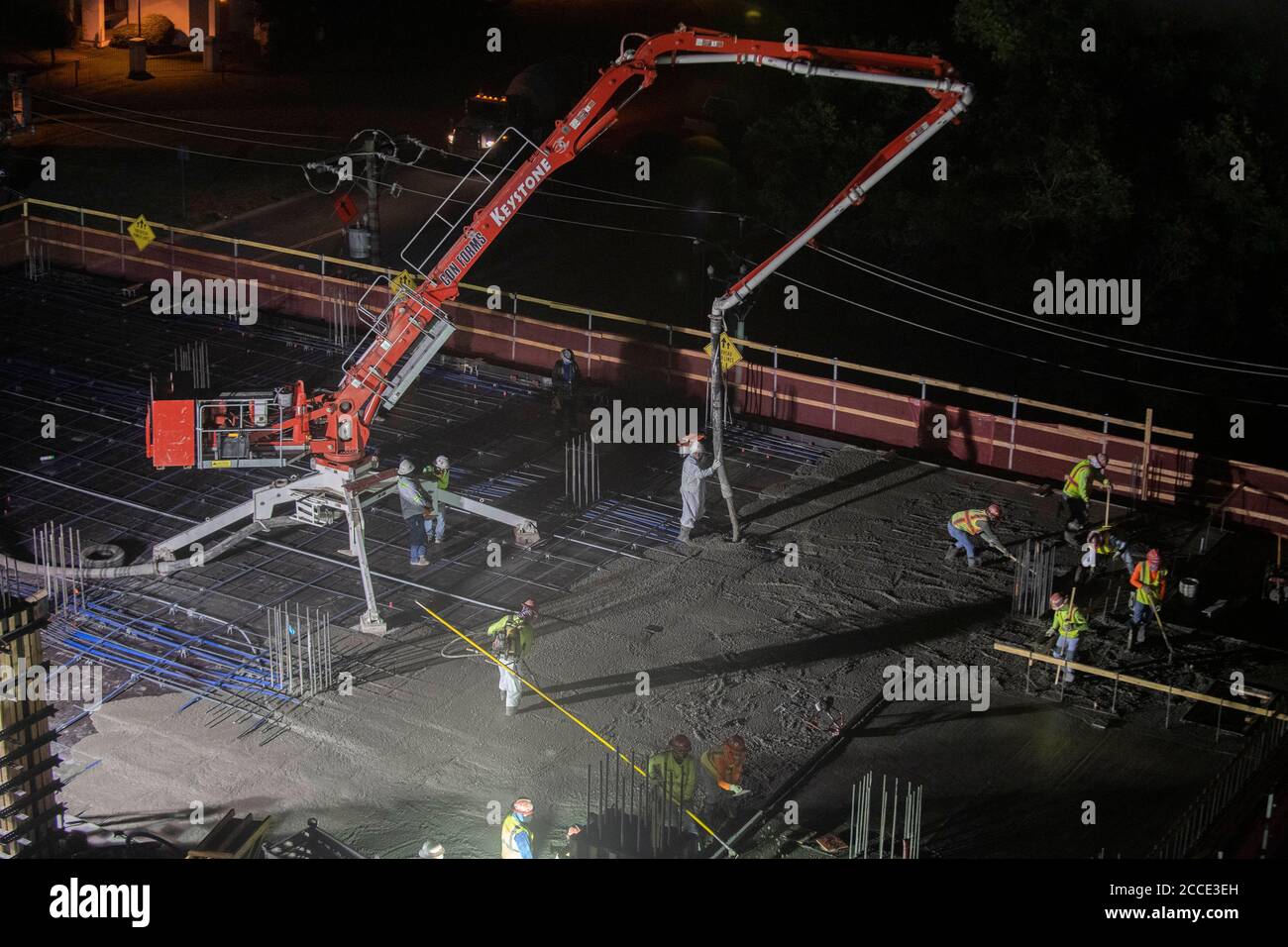 Austin, TX USA 25 juillet 2020: Le béton pompé coule à travers un tube sur le plancher d'un garage de stationnement, partie d'un bâtiment de 53 étages en construction, pendant une nuit-verse près du centre-ville d'Austin,. Banque D'Images