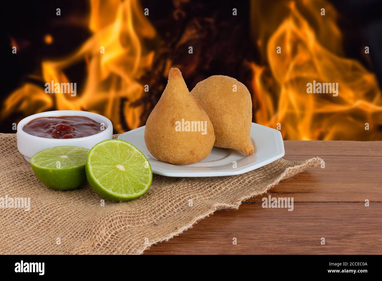 Coxinha. Plats traditionnels brésiliens frits au poulet. Arrière-plan avec feu défoqué Banque D'Images