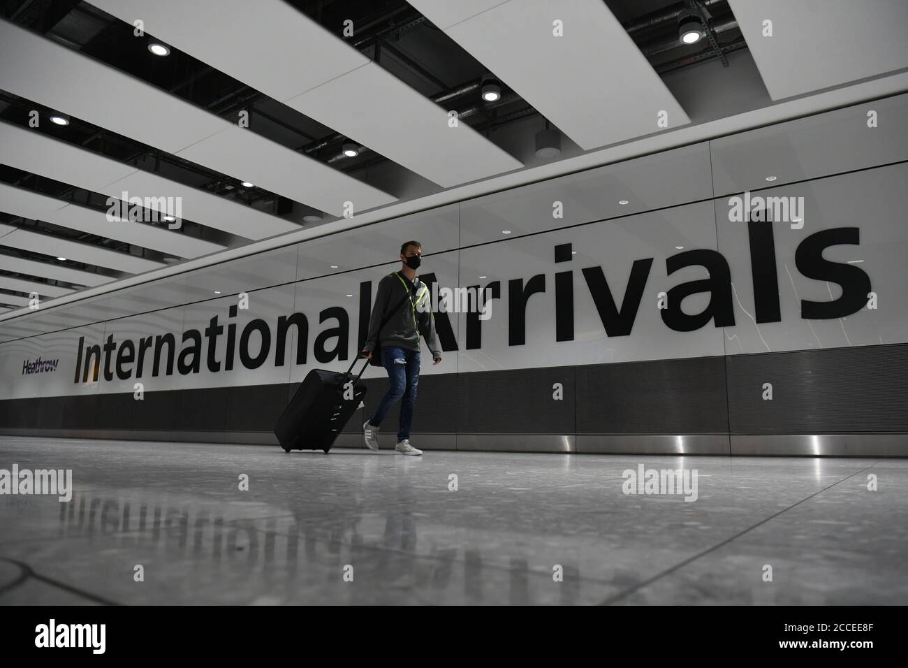 Un passager portant un masque facial arrivant à l'aéroport d'Heathrow après l'atterrissage d'un vol au départ de Dubrovnik, en Croatie. Le gouvernement britannique a annoncé qu'à partir de 4 heures du matin, samedi, les voyageurs en provenance de Croatie, d'Autriche et de Trinité-et-Tobago devront se mettre en quarantaine pendant 14 jours à leur arrivée. Banque D'Images
