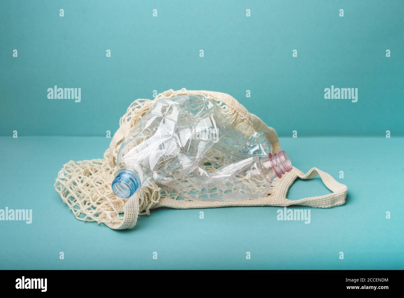 Sac à filet avec flacons en plastique sur fond bleu. Nettoyer notre Terre. Concept sans déchets, sans plastique. Style de vie durable. Banque D'Images