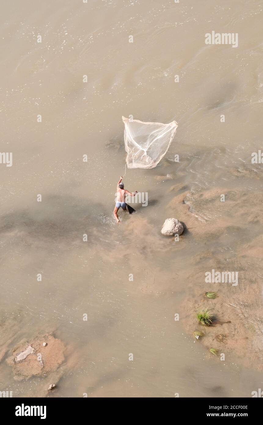 Un pêcheur qui se trouve dans le Tigre tente de pêcher en jetant un filet, près de Hasankeyf, dans la région orientale de l'Anatolie, dans le sud-est de la Turquie. Banque D'Images