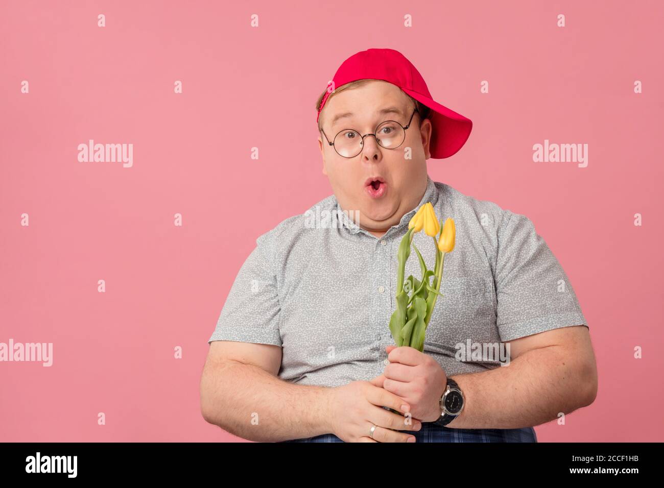 Romantique drôle homme comique en casquette rouge tenant des tulipes jaunes  avec étonnement look surpris. Maquette, affiche ou carte de vœux. Fête des  mères, V Photo Stock - Alamy