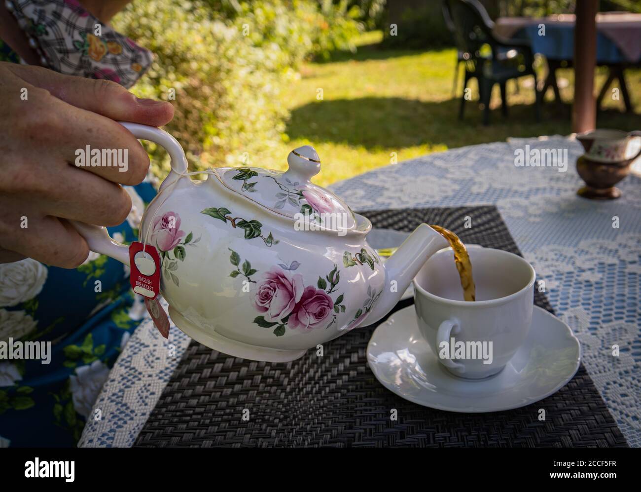 verser une tasse de thé réconfortante dans le jardin d'été Banque D'Images