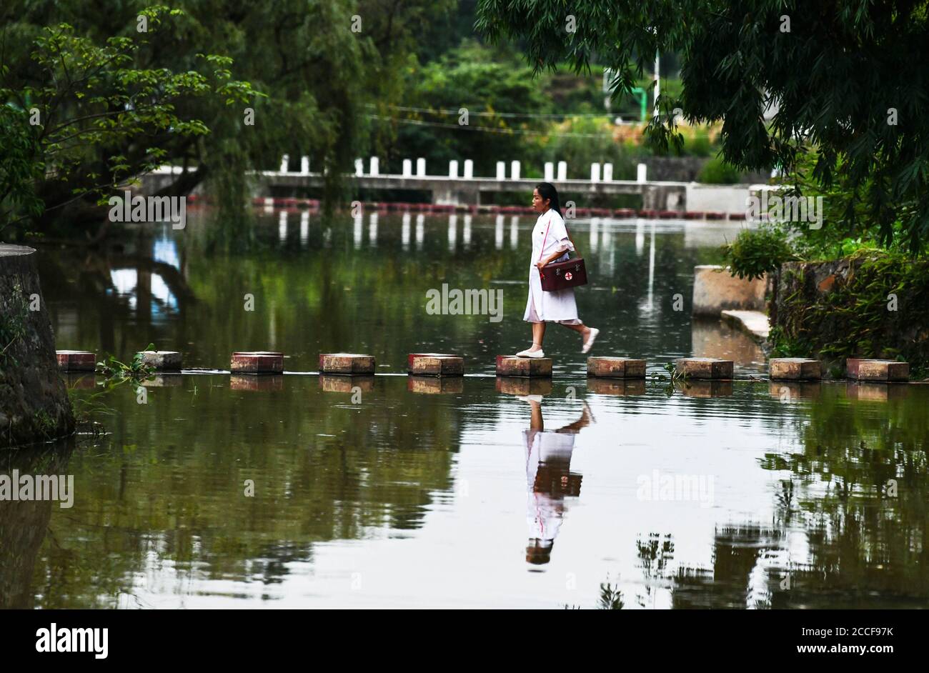 Beijing, province chinoise du Guizhou. 18 août 2020. Luo Mu est sur le point de rendre visite à une patiente du village de Cuiwei dans le comté de Longli, préfecture autonome de Qiannan Buyi-Miao, province de Guizhou, dans le sud-ouest de la Chine, le 18 août 2020. Luo Mu, 49 ans, médecin du groupe ethnique Buyi, travaille dans le village de Cuiwei, dans le comté de Longli. Diplômée d'une école de médecine en 2004, elle est rentrée dans le village servant de médaillé. Au cours des 16 dernières années, elle a traité environ 30 patients par jour et a réexaminé les patients environ 1,000 fois par année. Credit: Yang Wenbin/Xinhua/Alamy Live News Banque D'Images