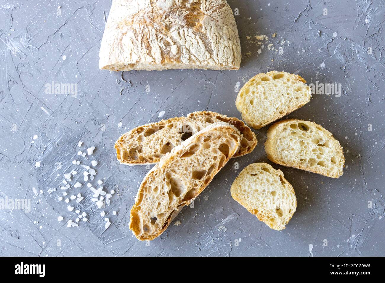 Pain frais coupé en tranches avec une couche de sel plate. Ciabatta Banque D'Images