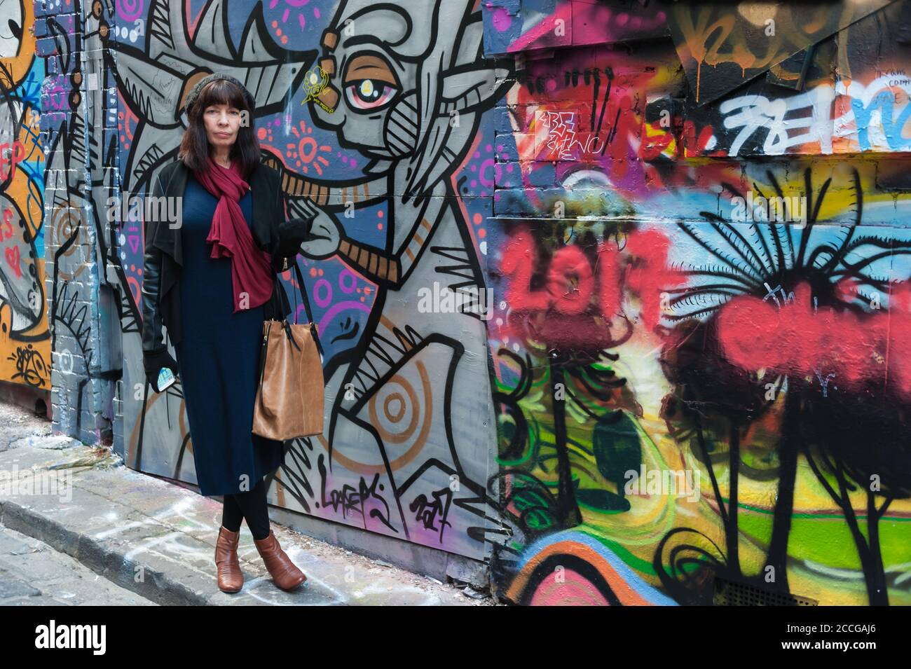Les touristes féminins se trouvent à côté de l'art de la rue coloré le long de la voie ACDC à Melbourne, Victoria, Australie. Banque D'Images