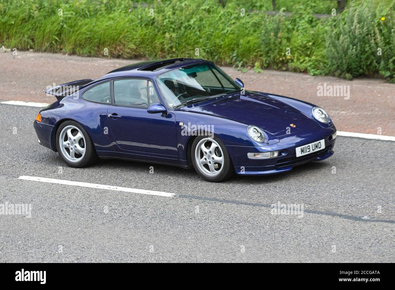 Années 1995 90 Carrera bleu Porsche 911 Carrera ; véhicules en mouvement, voitures de sport conduisant véhicule sur les routes du Royaume-Uni, moteurs, motorisation sur le réseau autoroutier M6. Banque D'Images