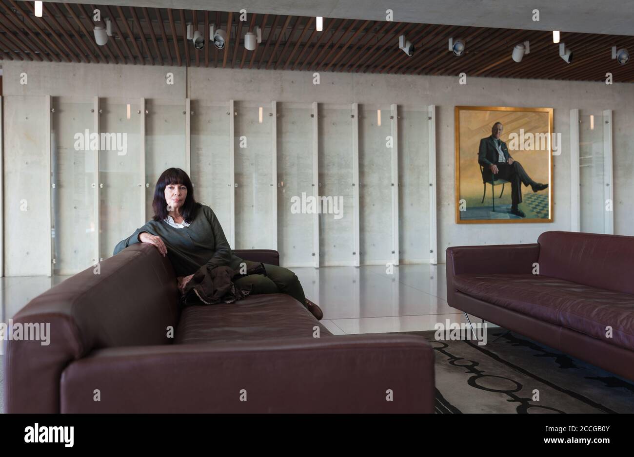 Femme assise dans le salon juxtaposée à un portrait peint d'un homme assis sur une chaise dans la galerie nationale de portrait de l'Australie à Canberra. Banque D'Images