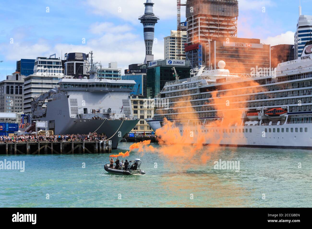 Port d'Auckland, Nouvelle-Zélande. Un homme dans un bateau gonflable laisse échapper une flamme de fumée pour simuler une urgence, surveillée par une grande foule. 1/26/2019 Banque D'Images