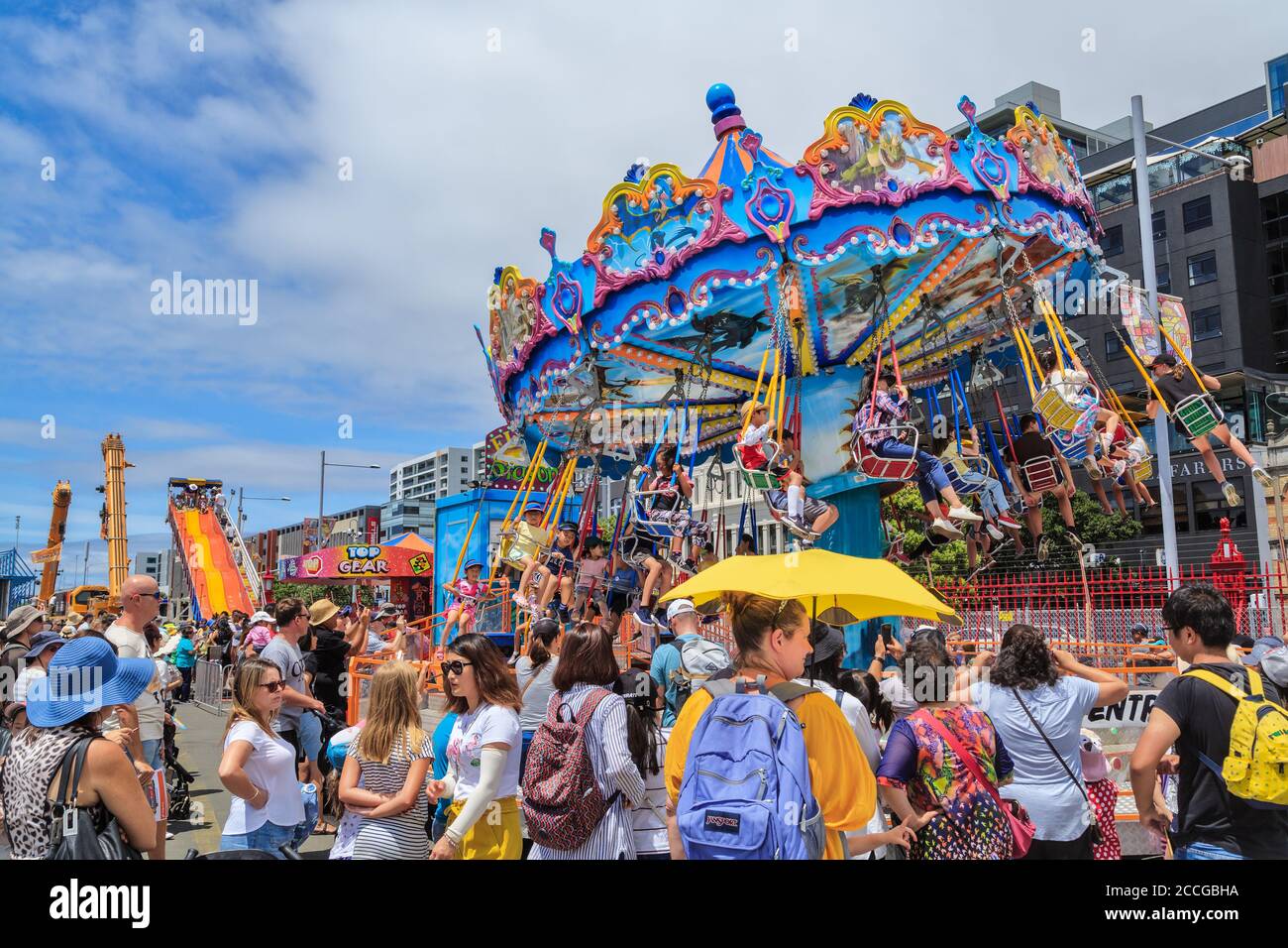 Tours de carnaval. Les enfants sur un carrousel de balançoire, entouré d'une grande foule. Photographié à Auckland, Nouvelle-Zélande, 1/27/2019 Banque D'Images