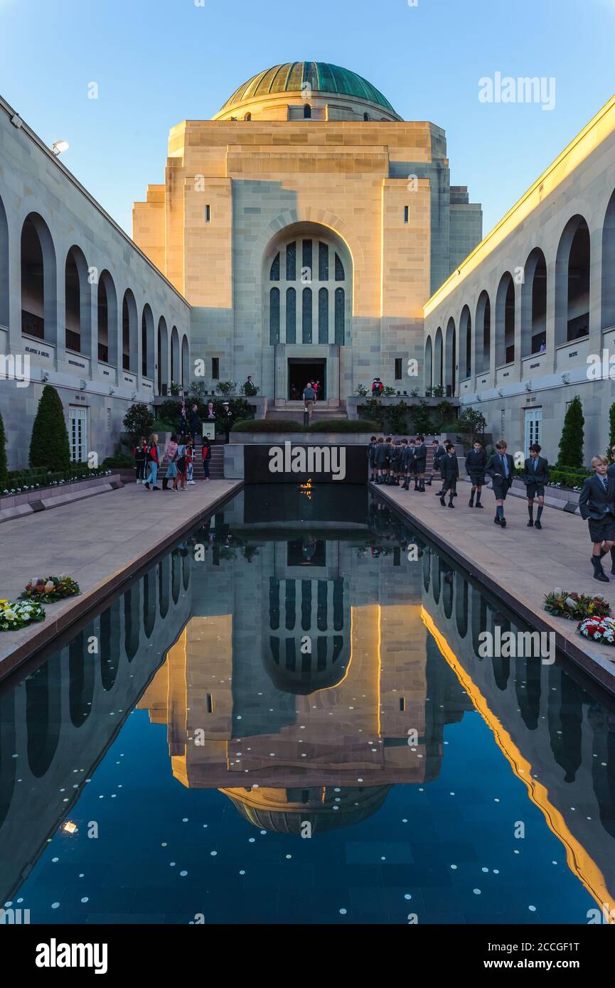 Vue sur la piscine de la cour, les réflexions des bâtiments et les groupes touristiques menant à la citadelle et au tombeau du soldat inconnu à Canberra, en Australie. Banque D'Images