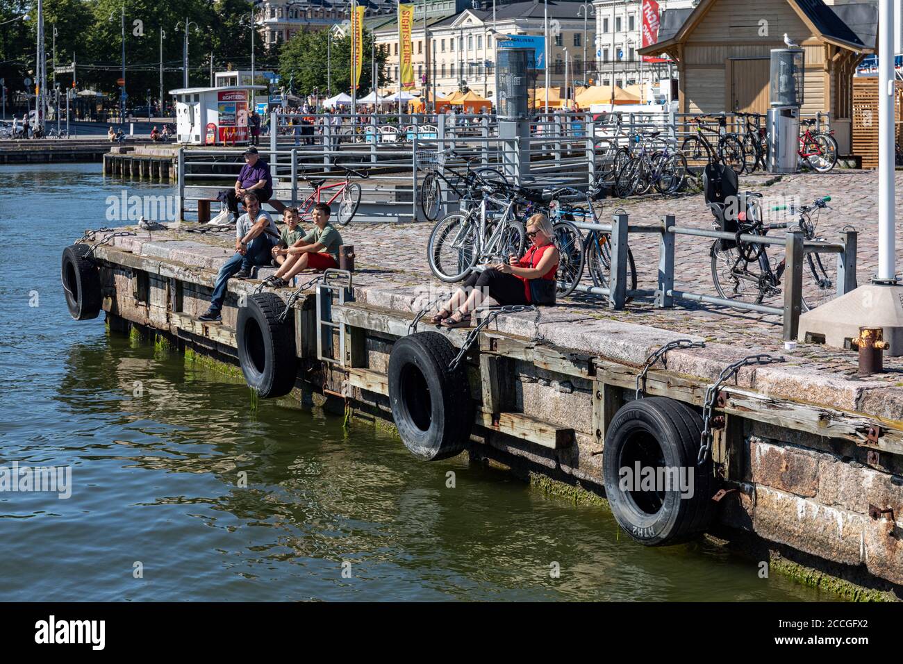 Les personnes assises sur la place du marché accoster un après-midi ensoleillé à Helsinki, en Finlande Banque D'Images