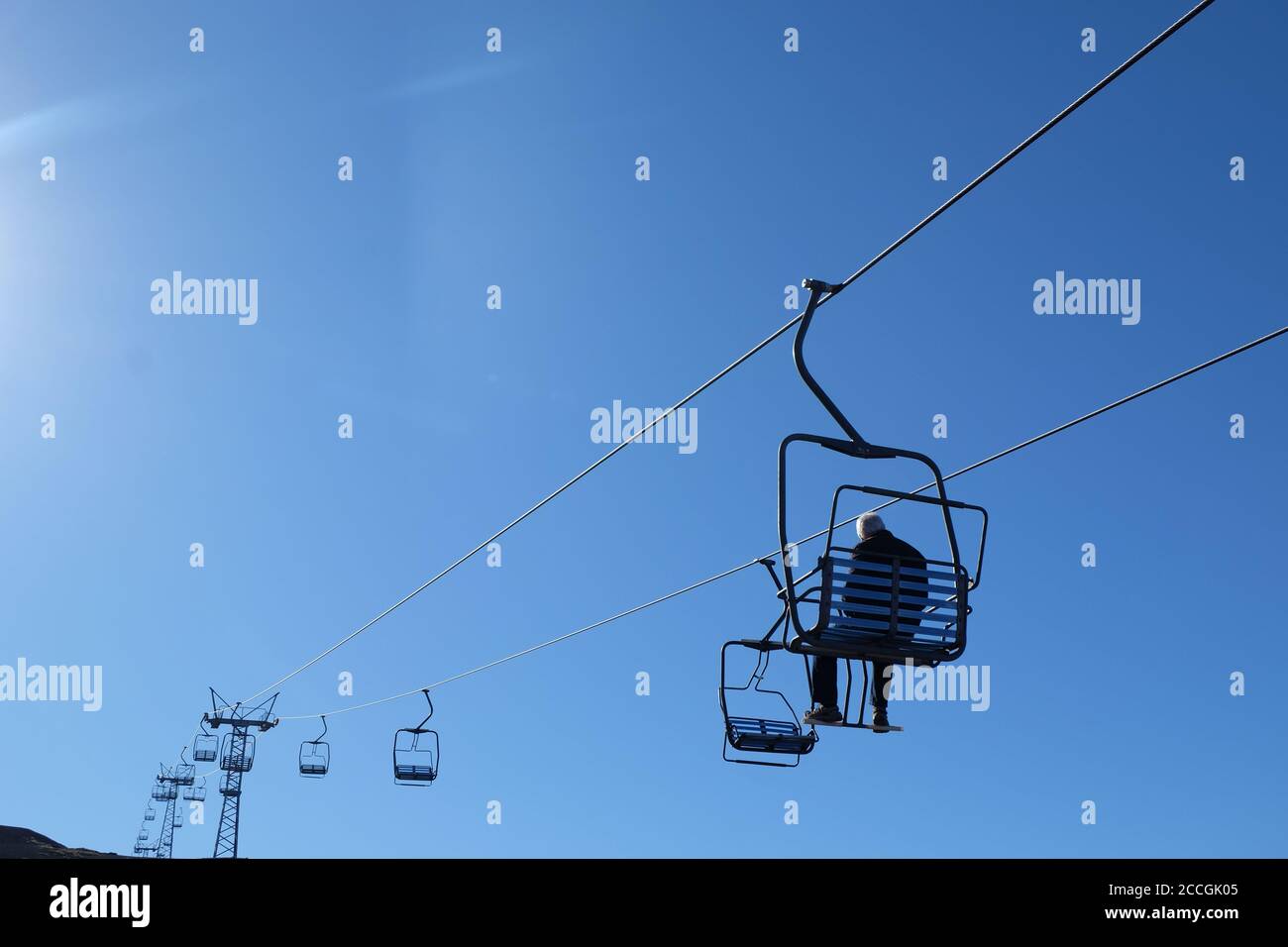 Les remontées mécaniques sont vides ! Un touriste solitaire bénéficie d'une vue magnifique sur les remontées mécaniques d'Osorno. Banque D'Images