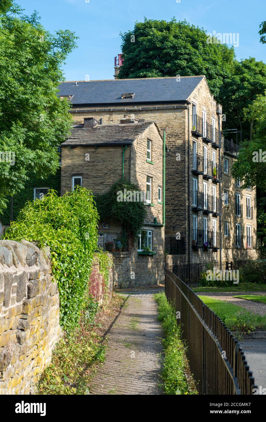 Vue d'été d'un sentier attrayant menant à un moulin victorien maintenant converti en appartements à Bingley, West Yorkshire Banque D'Images