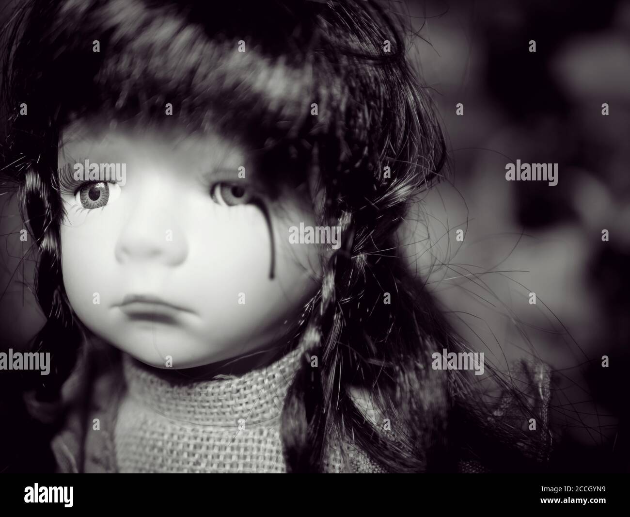 Lutte contre la violence chez les enfants concept de la campagne pour les problèmes familiaux : petite fille adorable poupée pleurs de sang de déchirure de la violence sociale familiale. Noir et blanc c Banque D'Images