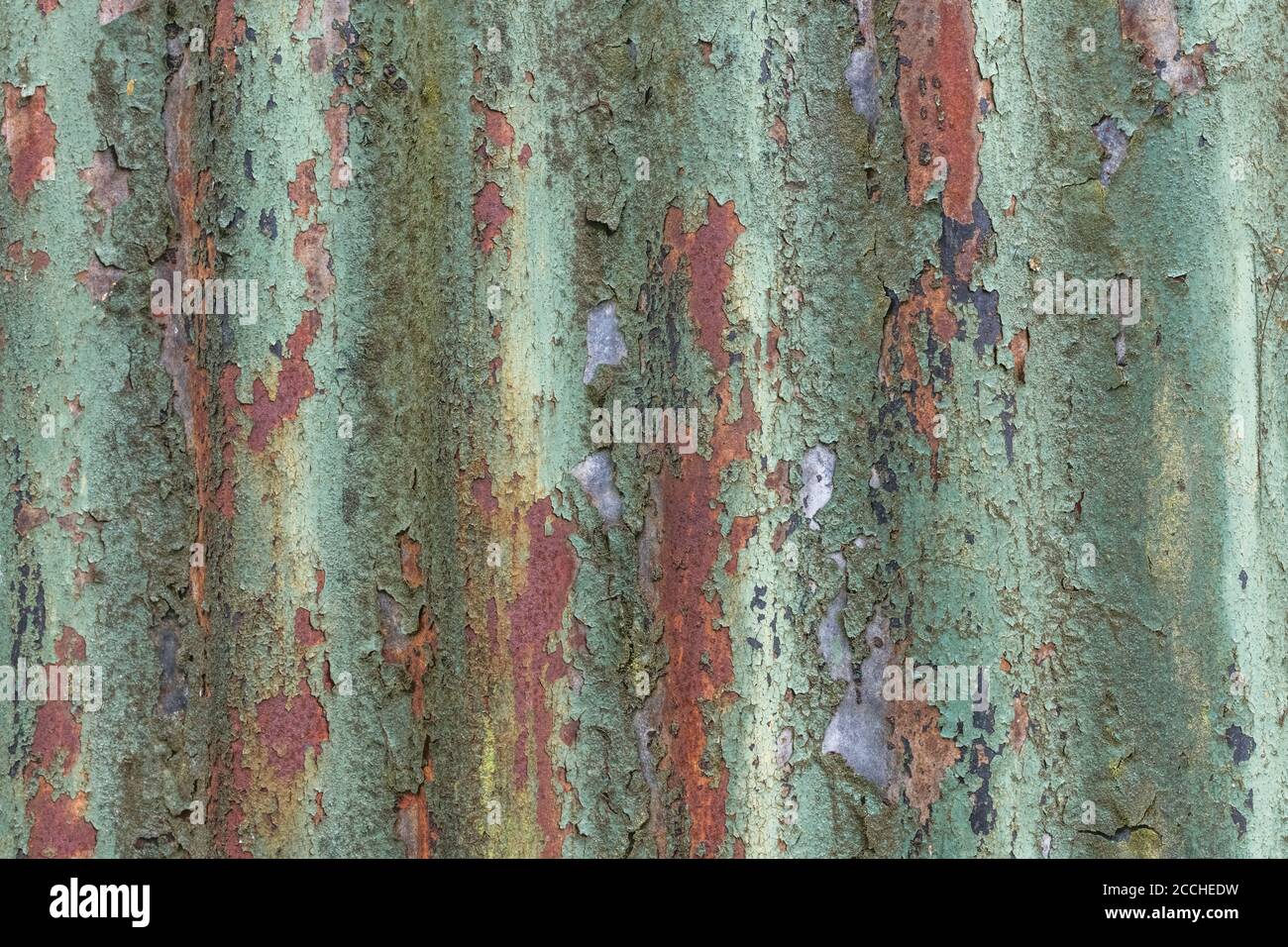 Couleurs orange et sarcelle décolorées, peinture écaillée et abri de jardin en étain ondulé rouillé.Belle vieille texture de peinture décolorée par la lumière. Banque D'Images