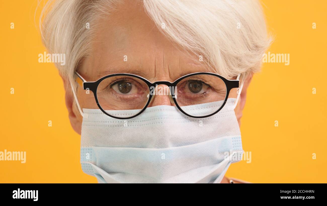 Gros plan, portrait d'une femme âgée sérieuse avec des lunettes et un masque médical. Photo de haute qualité Banque D'Images