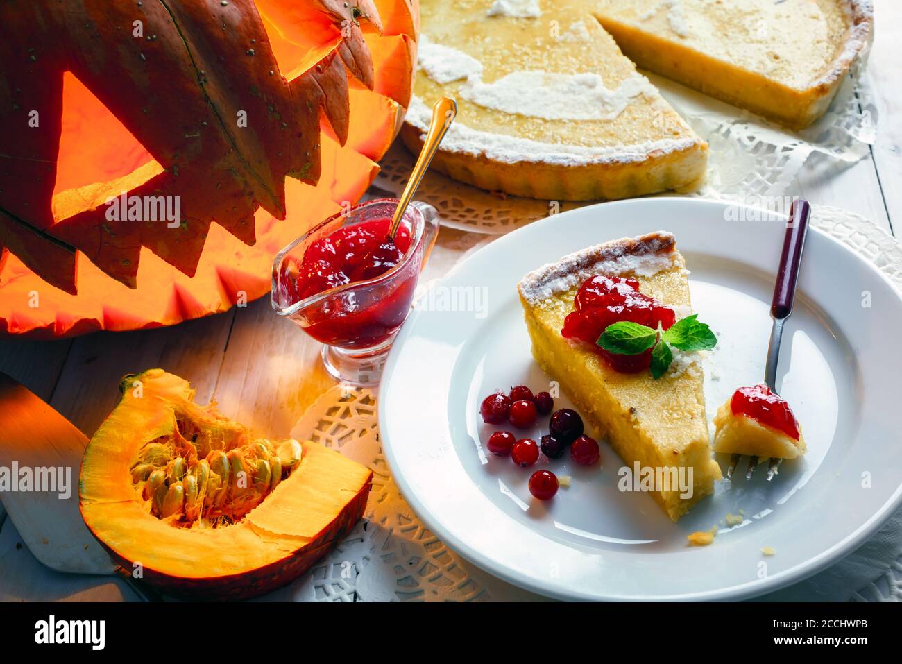 Petit gâteau de citrouille maison d'halloween avec feuille de menthe et confiture de baies de vache sur une assiette blanche. Cuisine traditionnelle de vacances Banque D'Images
