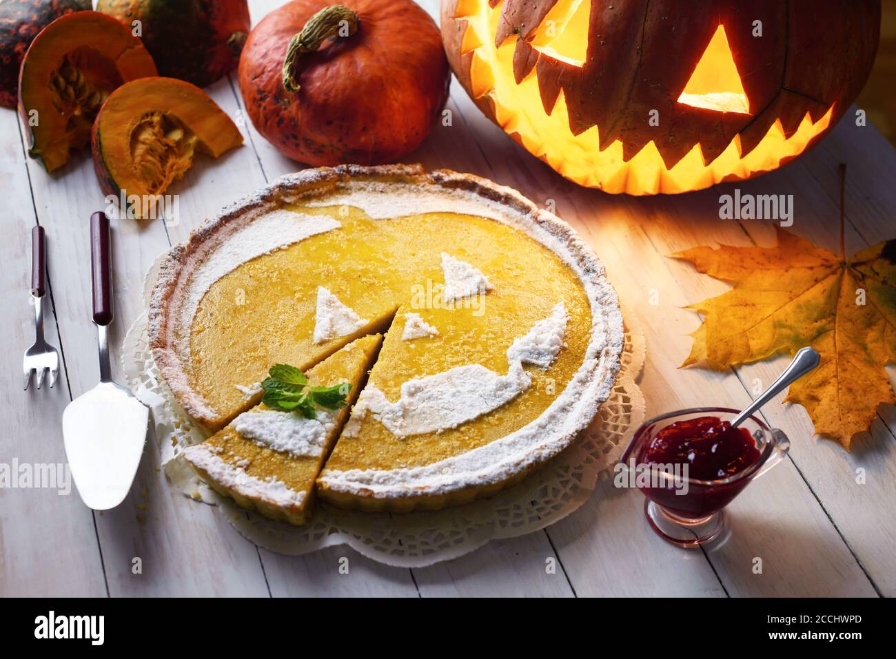 Gâteau de citrouille d'halloween maison sucré avec feuille de menthe. Jack-o-lanterne, feuilles de frêne et confiture de baies de vache autour Banque D'Images