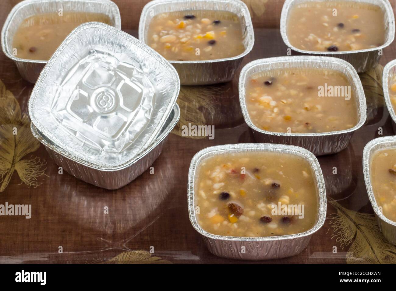 Dessert turc traditionnel Asure sur plateau avec louche et bols en aluminium, récipients en aluminium. Plats à emporter. Banque D'Images