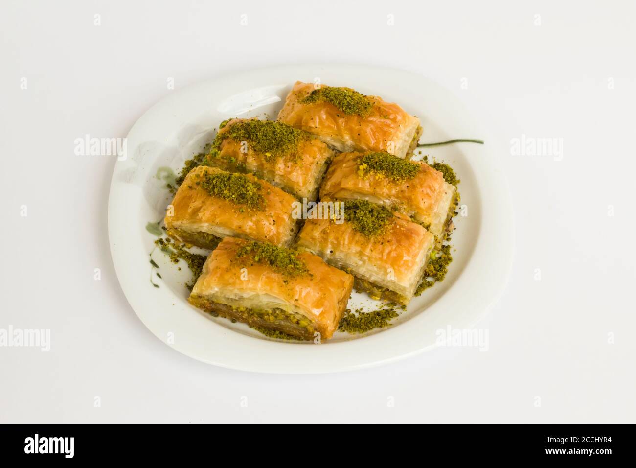 Pâtisserie turque traditionnelle dessert, Pistachio Baklava dans une assiette à la surface blanche avec espace de copie Banque D'Images