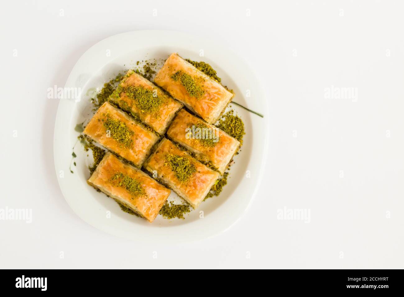 Pâtisserie turque traditionnelle dessert, Pistachio Baklava dans une assiette à la surface blanche avec espace de copie Banque D'Images