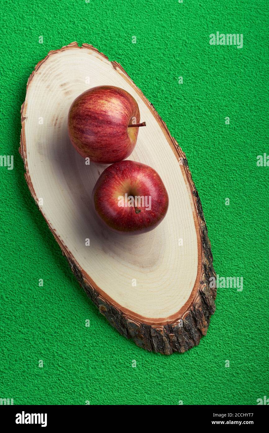 pommes rouges sur un arbre coupé et sur un vert arrière-plan Banque D'Images