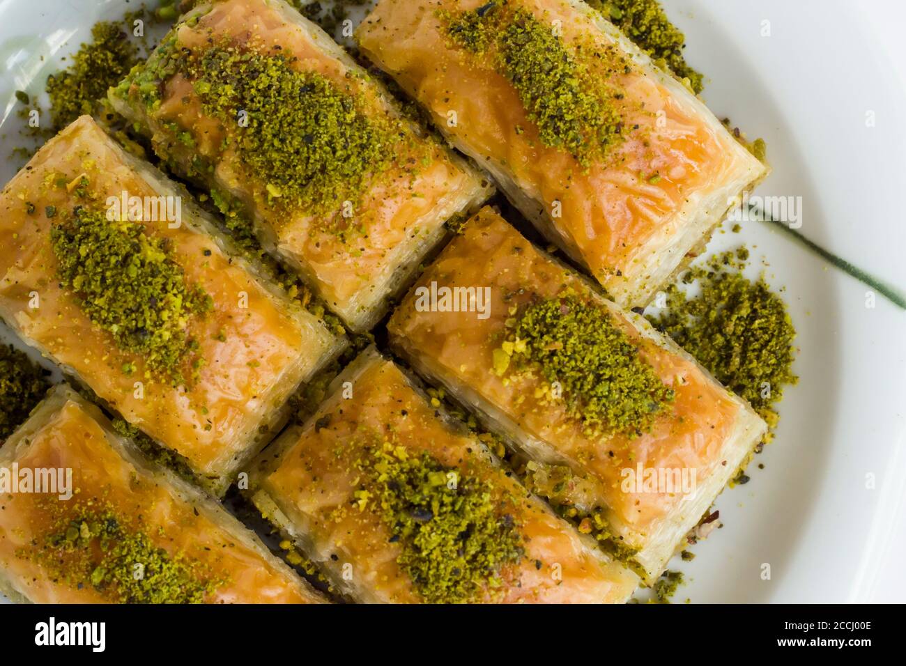Pâtisserie turque traditionnelle dessert, Pistachio Baklava dans une assiette à la surface blanche avec espace de copie Banque D'Images