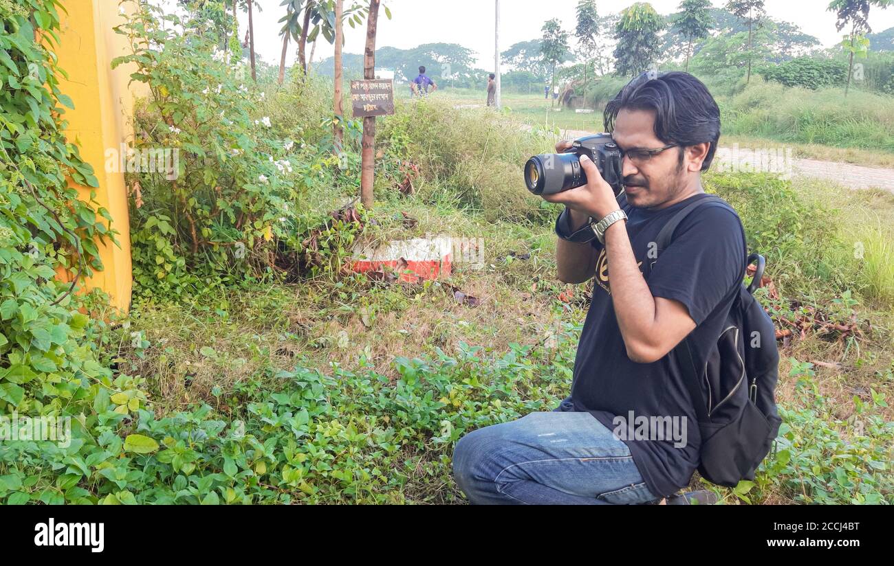 28 juillet 2020, Dhaka, Bangladesh . Garçon photographe . Garçon prenant des photos avec son appareil photo Canon . Banque D'Images