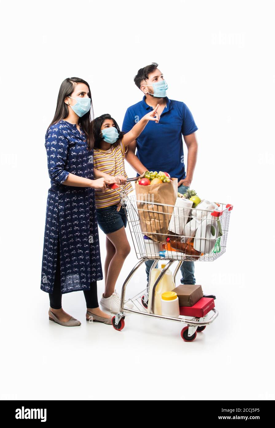 Famille indienne Shopping avec des enfants pendant l'épidémie de virus. Mère, père et fille portant un masque chirurgical achetant une épicerie dans un supermarché. Famille i Banque D'Images