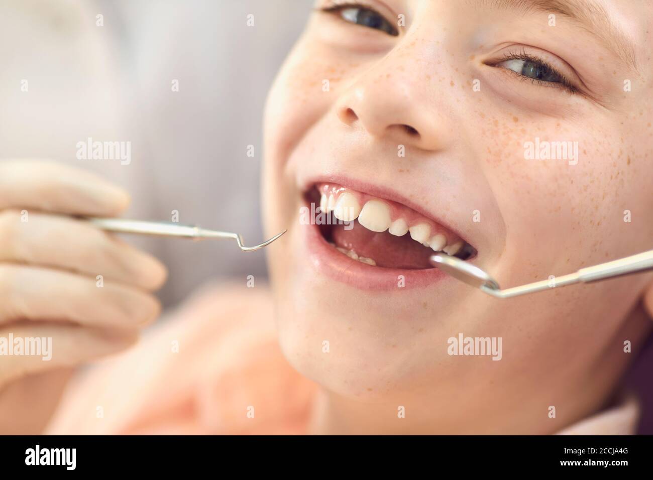 Enregistrement de garçon souriant en gros plan dans le cabinet du dentiste. Prévention des caries et traitement dentaire. Banque D'Images