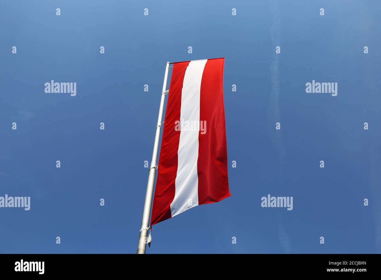 Drapeau autrichien devant un ciel bleu Banque D'Images