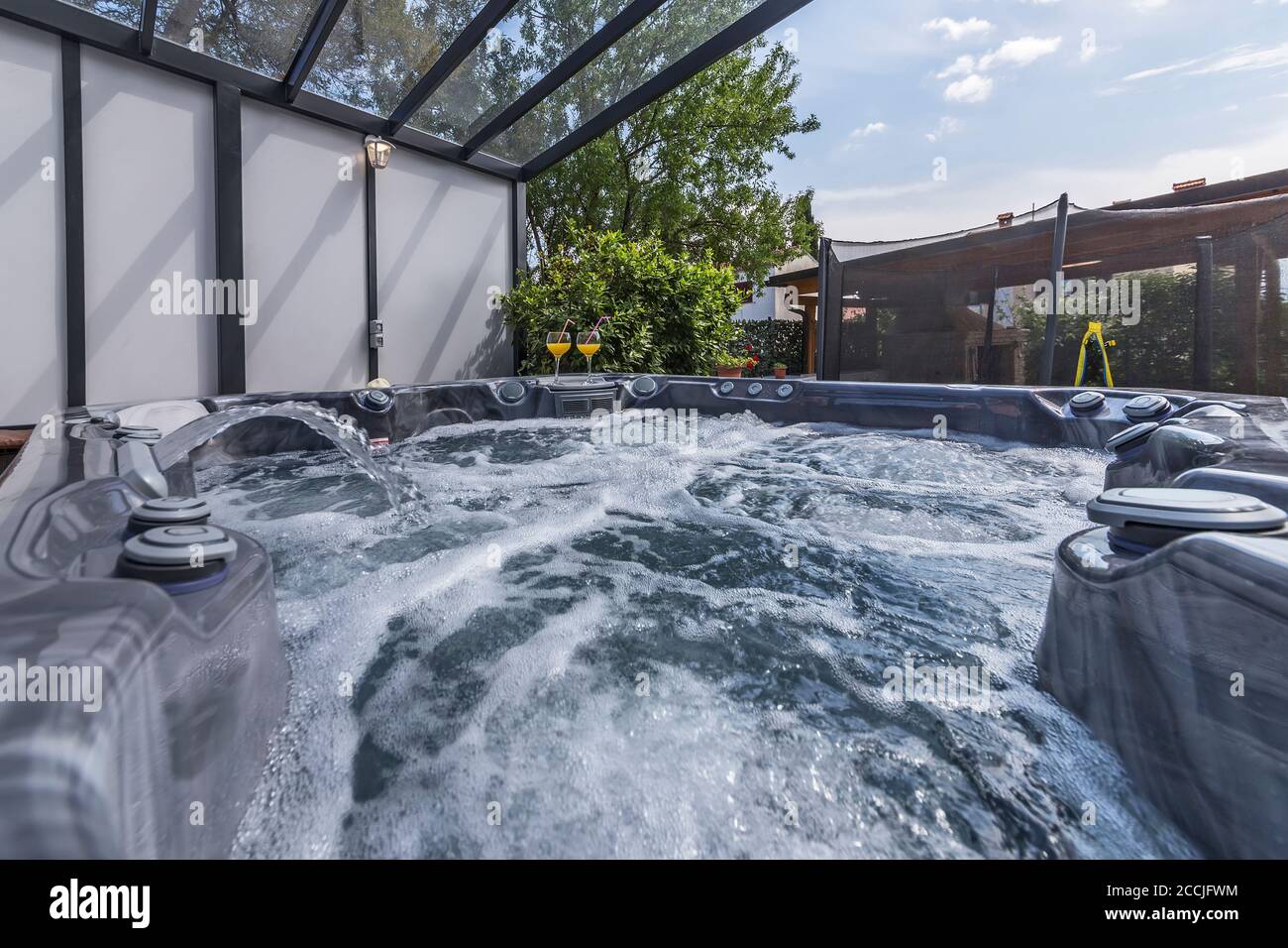 piscine extérieure moderne avec massages, boissons fraîches et vin Banque D'Images