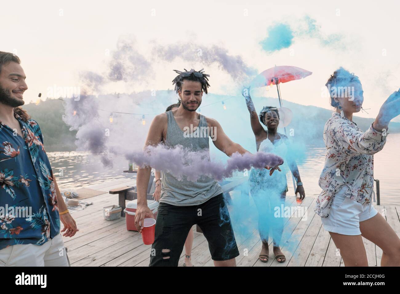 Groupe d'amis debout sur un quai et dansant ils visite du festival des couleurs Banque D'Images