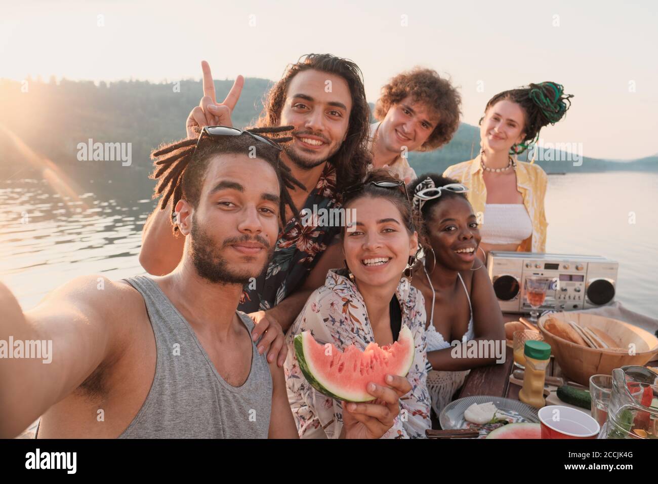 Portrait d'un groupe heureux d'amis souriant et posant à appareil-photo ils font le portrait de selfie pendant le pique-nique à l'extérieur Banque D'Images