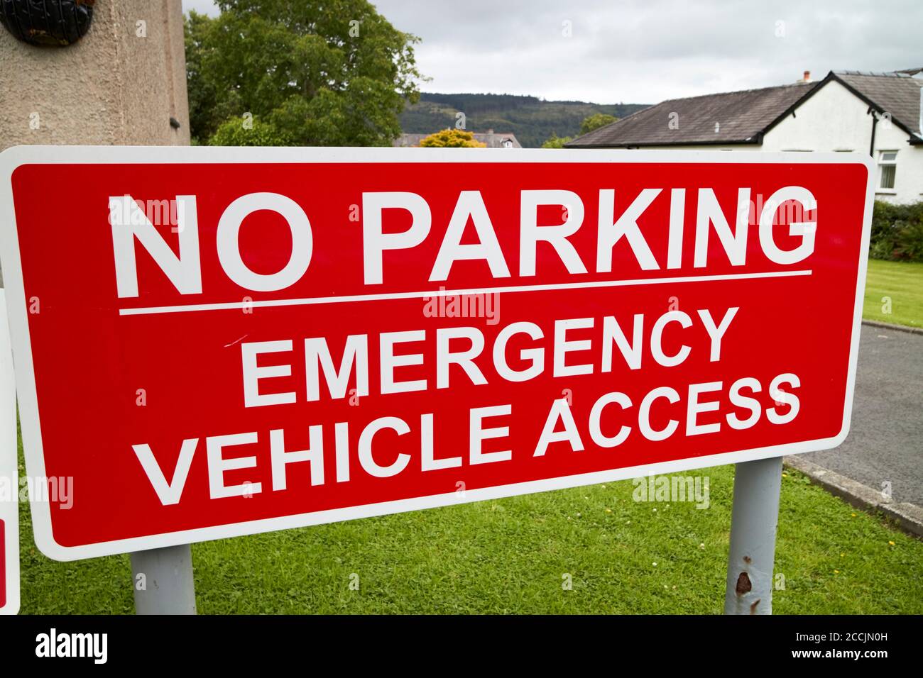 rouge pas de parking panneau d'accès d'urgence à l'extérieur de la caserne de pompiers dans le district de coniston lake, cumbria, angleterre, royaume-uni Banque D'Images