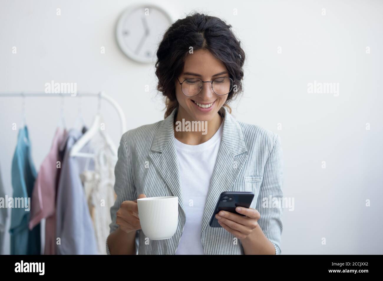 Un styliste heureux qui profite d'une pause avec une tasse de café. Banque D'Images