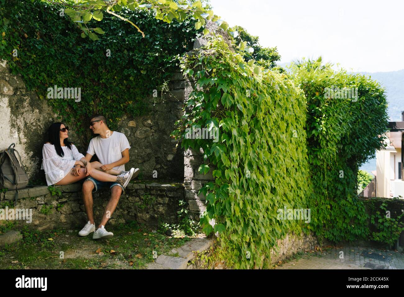 Jeune couple amoureux assis sur le banc, Bellagio, Italie Banque D'Images