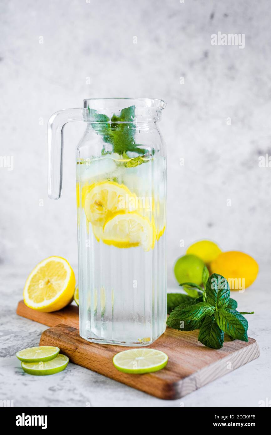 Détox eau avec citron, lime et menthe et glaçons Banque D'Images