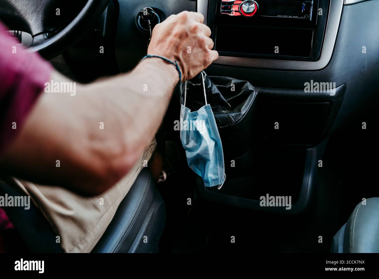Homme avec masque facial conduisant une voiture pendant une pandémie Banque D'Images
