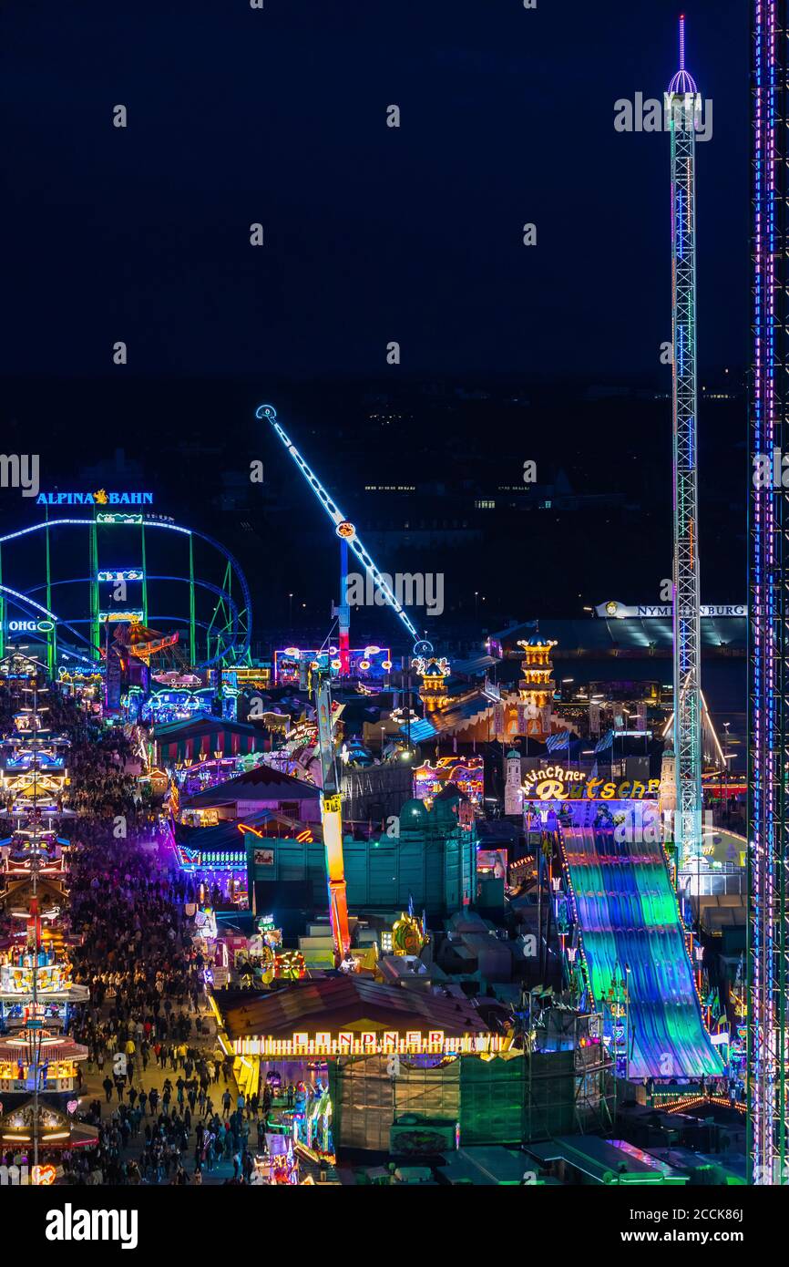 Allemagne, Bavière, Munich, Drone vue sur le parc d'attractions illuminé pendant l'Oktoberfest la nuit Banque D'Images