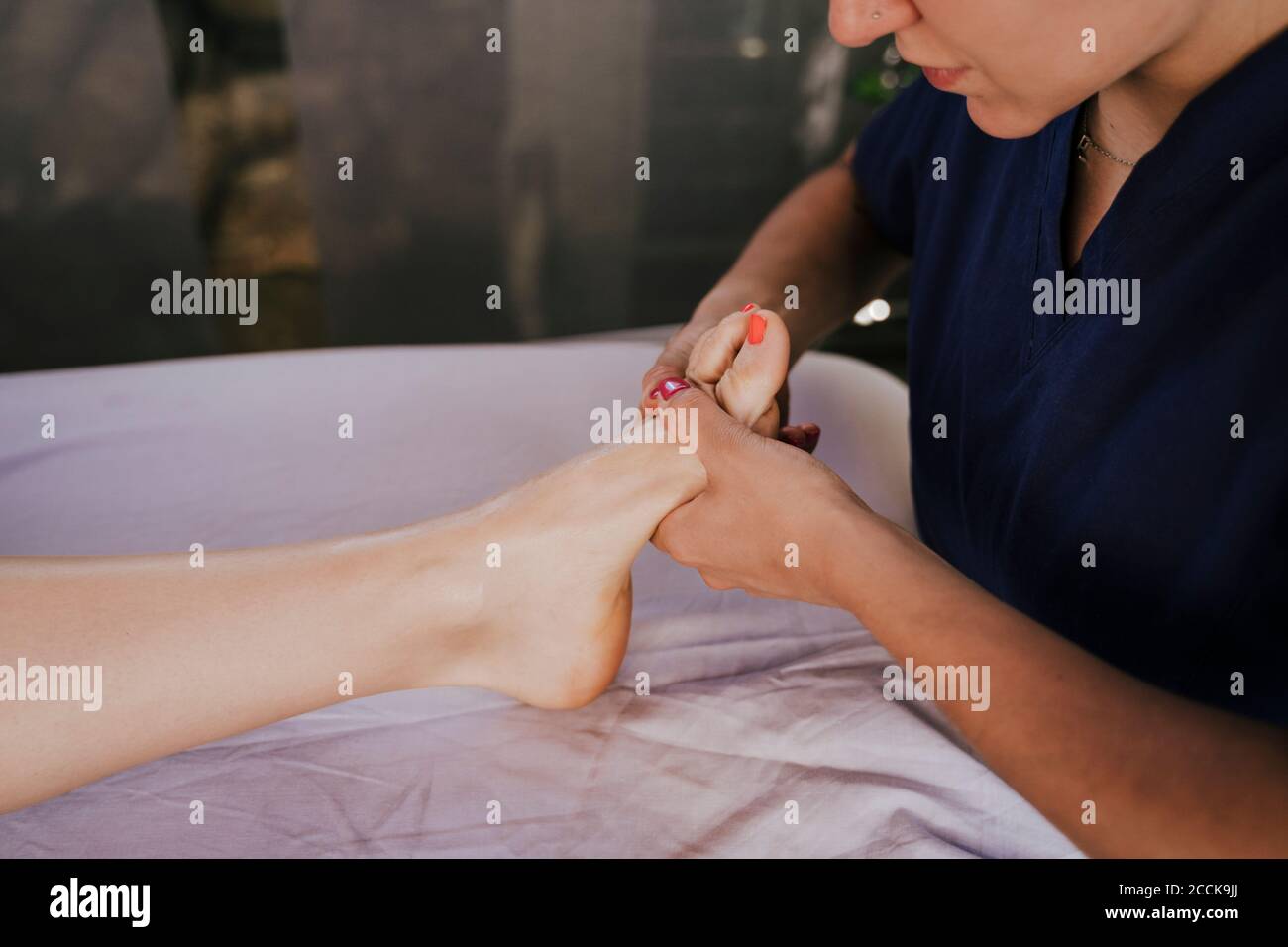 Gros plan de la femme thérapeute donnant un massage des pieds à la femme table dans le centre de remise en forme Banque D'Images