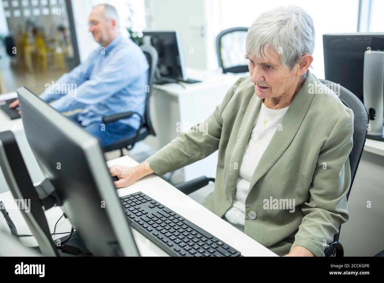 Personnes âgées actives assistant à un cours informatique, travaillant sur PC Banque D'Images