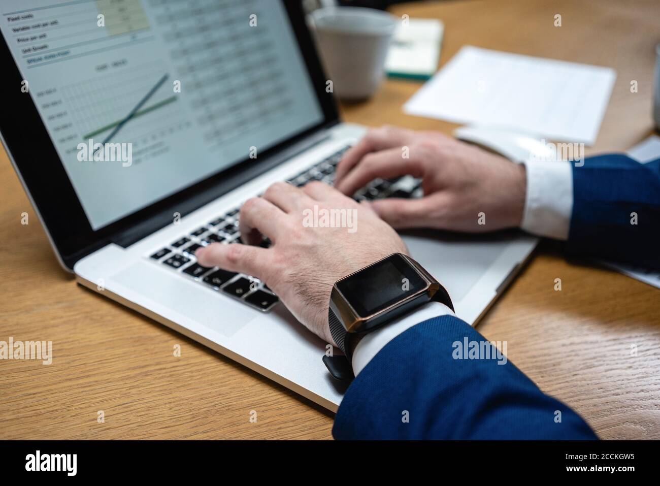 Gros plan sur la frappe d'un homme d'affaires tout en utilisant un ordinateur portable au bureau dans un espace de travail créatif Banque D'Images