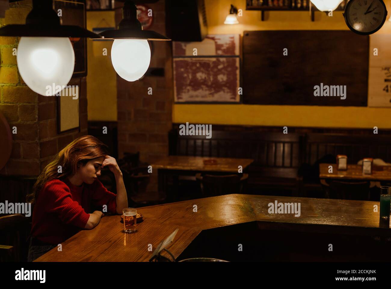 Triste femme avec un verre de bière sur le comptoir du bar restaurant Banque D'Images