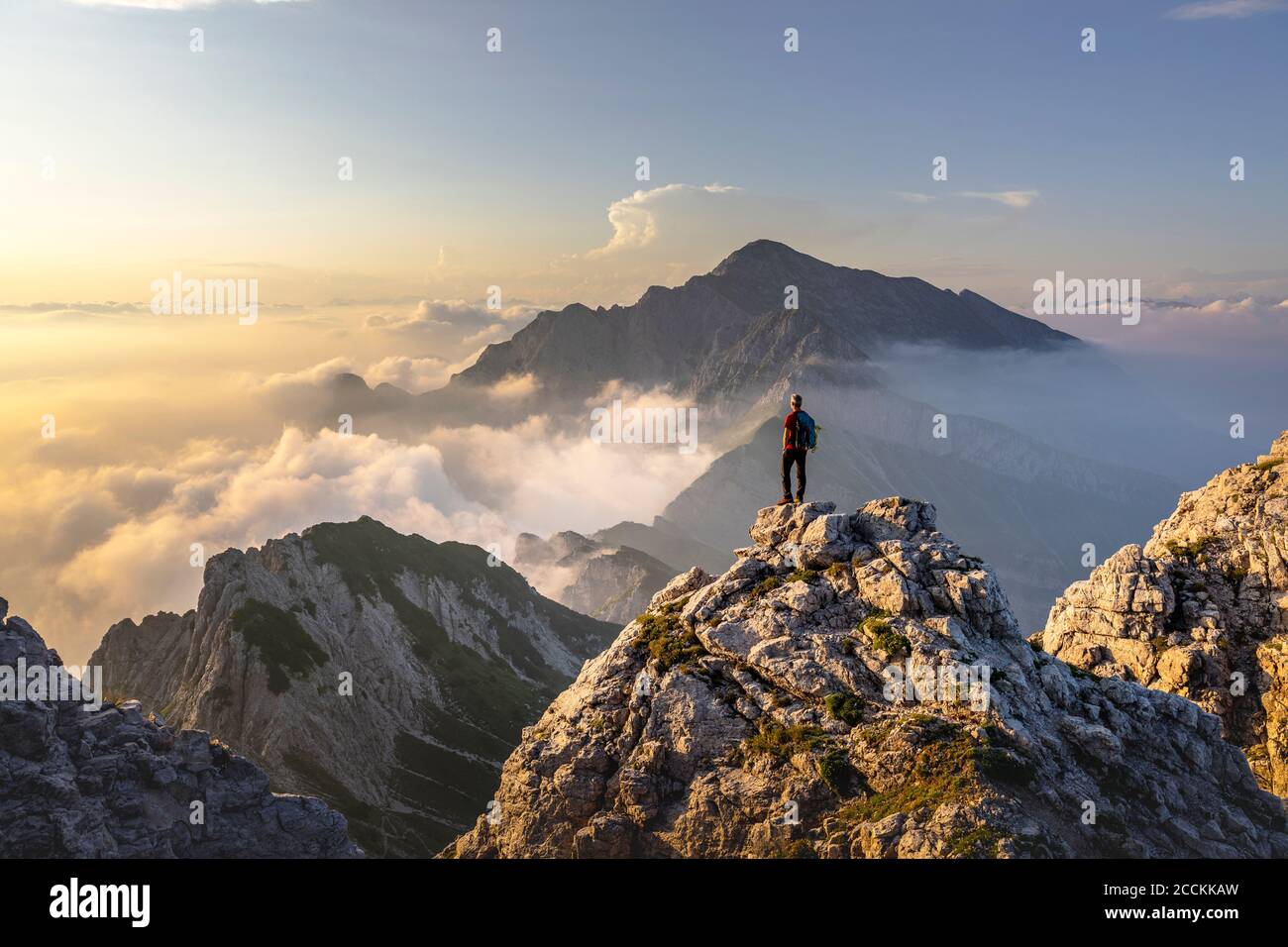 Randonneur admirant une vue magnifique en se tenant sur le sommet de la montagne aux Alpes de Bergamasque, Italie Banque D'Images